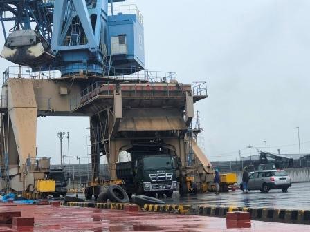 Loading discharged cargo onto truck via hopper