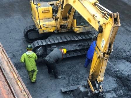 Removing adhered cargo on the excavator in the hold